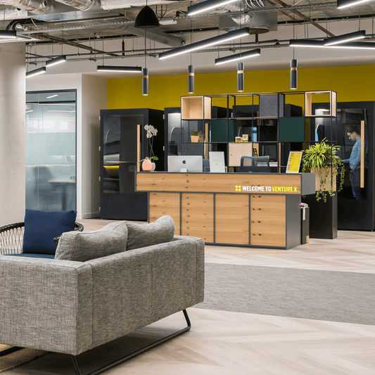 Black linear suspended LED lights and pendants installed in a reception area.