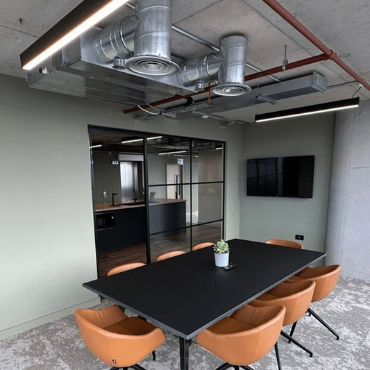 An office conference room with the black SKYline suspended ceiling lighting installed.