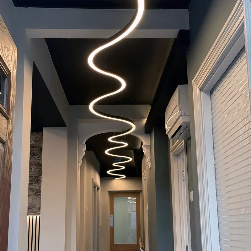 A long custom made curved linear LED ceiling light installed in a corridor.