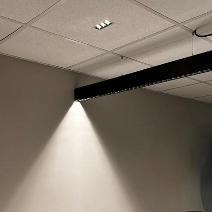 Square optics on a black suspended linear ceiling fitting for an excellent UGR rating.
