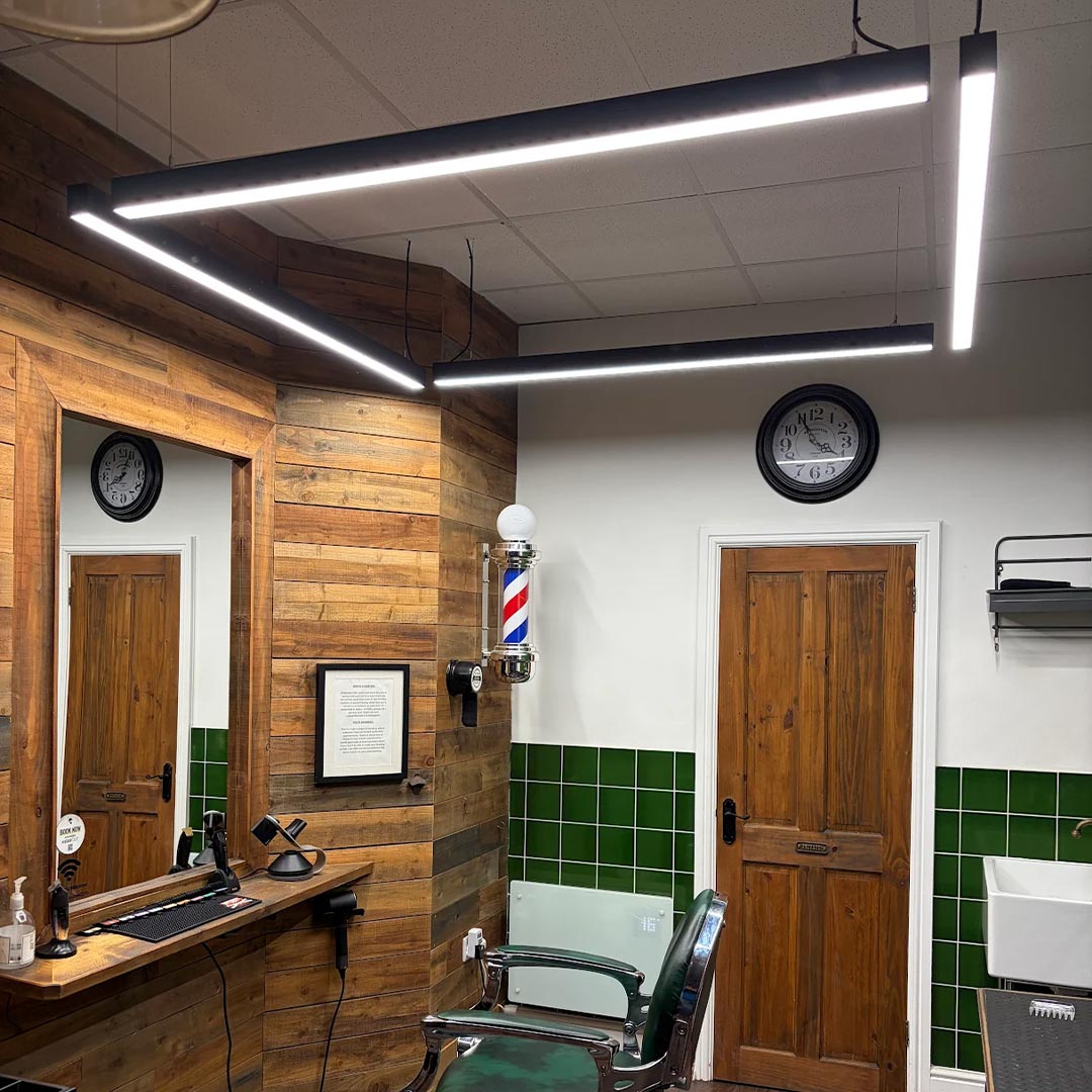 4 suspended 1.5m led Skyline light fittings arranged in a rectangle configeration in a barbers.