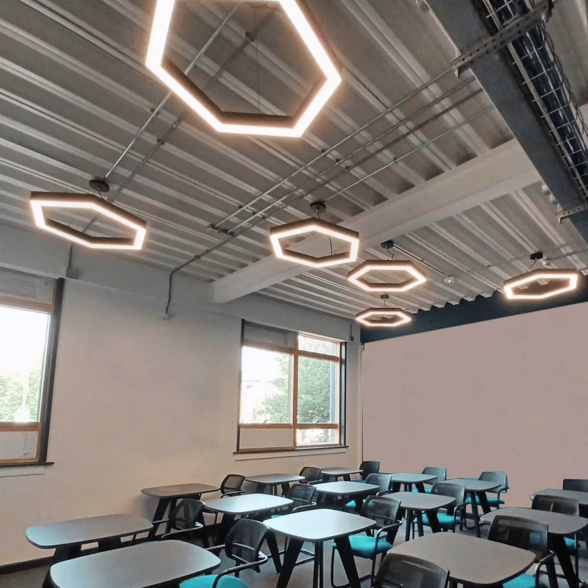 Multiple hexagon pendant lights installed within a classroom.