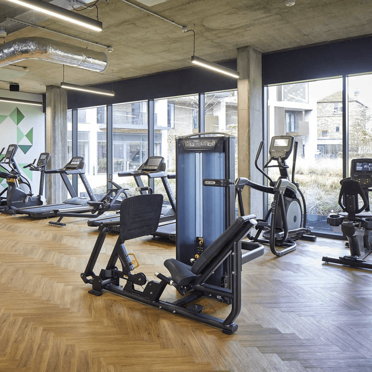 The black linear lights installed within a gym that has industrial styling.