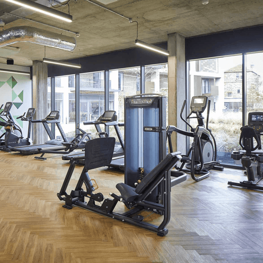 The black linear lights installed within a gym that has industrial styling.