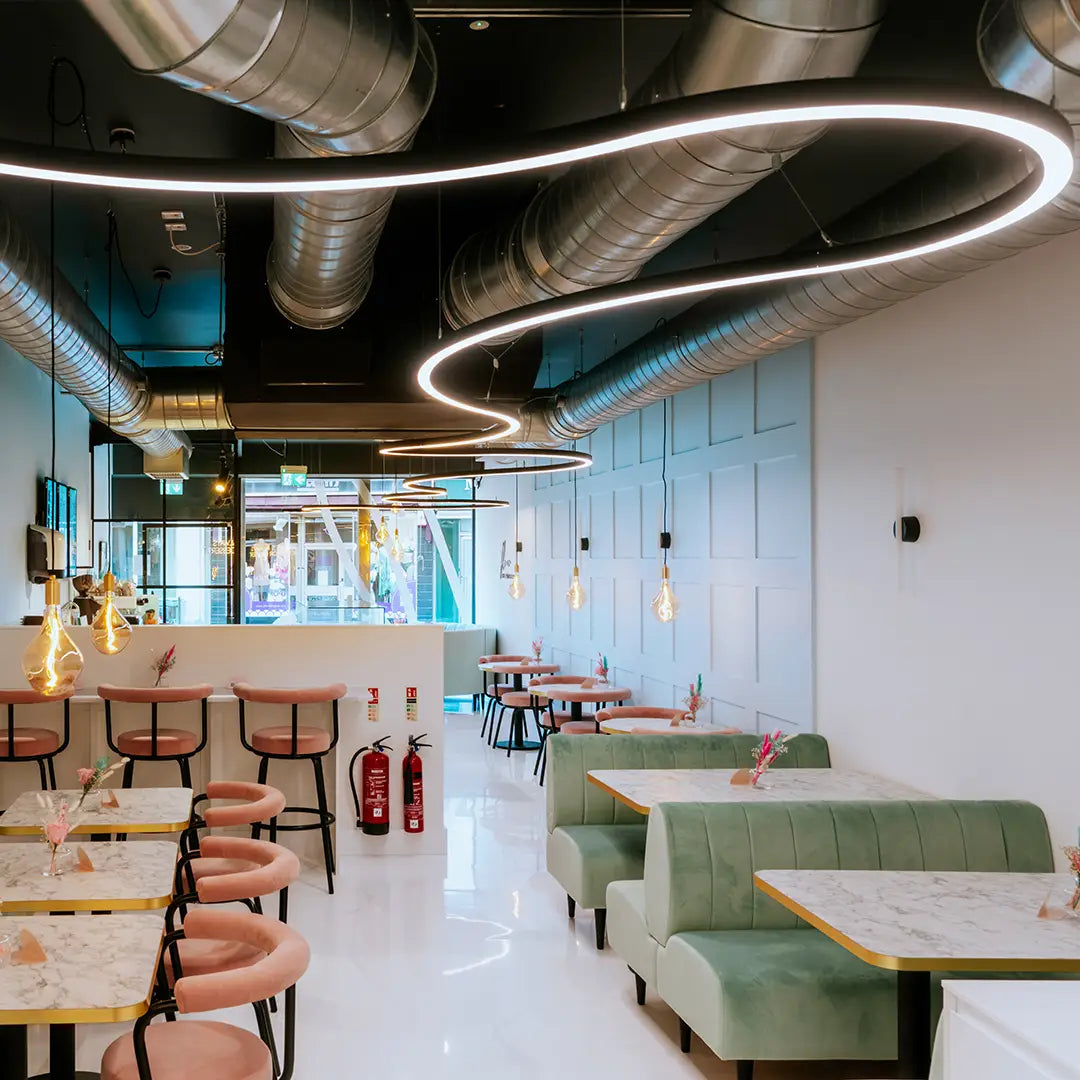 Modern restaurant interior with a decorative suspended lighting fixture in a long flowing design.