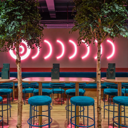 RGBW bespoke made arc led lights and ring lights installed on a wall as a statement piece within a restaurant.